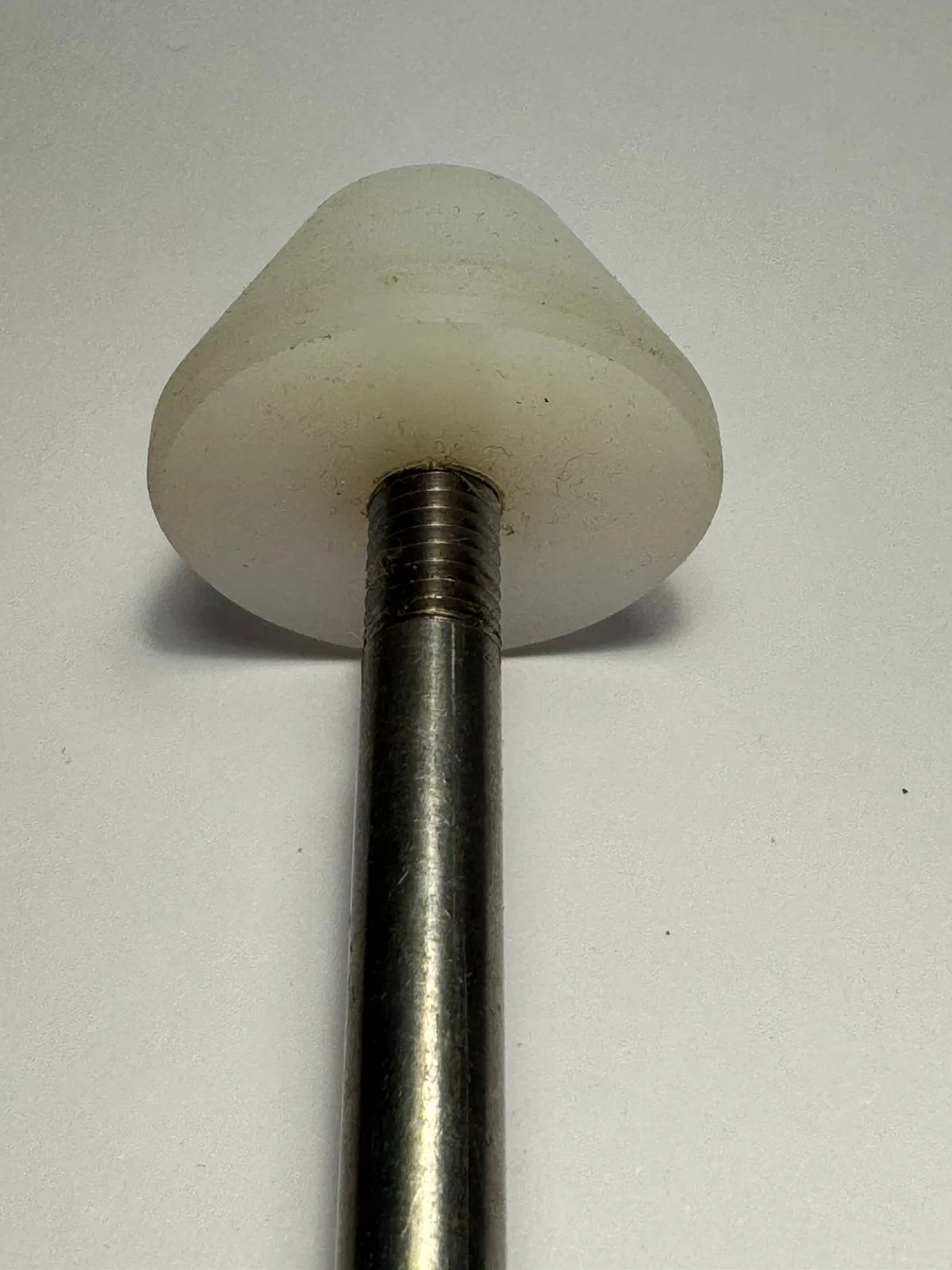Detalle de cabezal blanco de Teflon unido a un vástago metálico, fabricado por Tornería Wirth